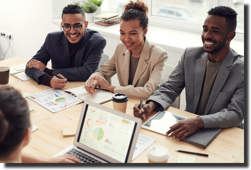 three-people-smiling-while-having-a-meeting